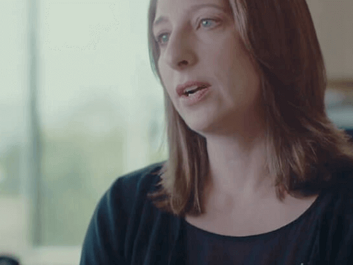 Persona sentada en interiores con un fondo suave.